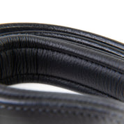 Close-up of a coiled black rubber hose on a white background