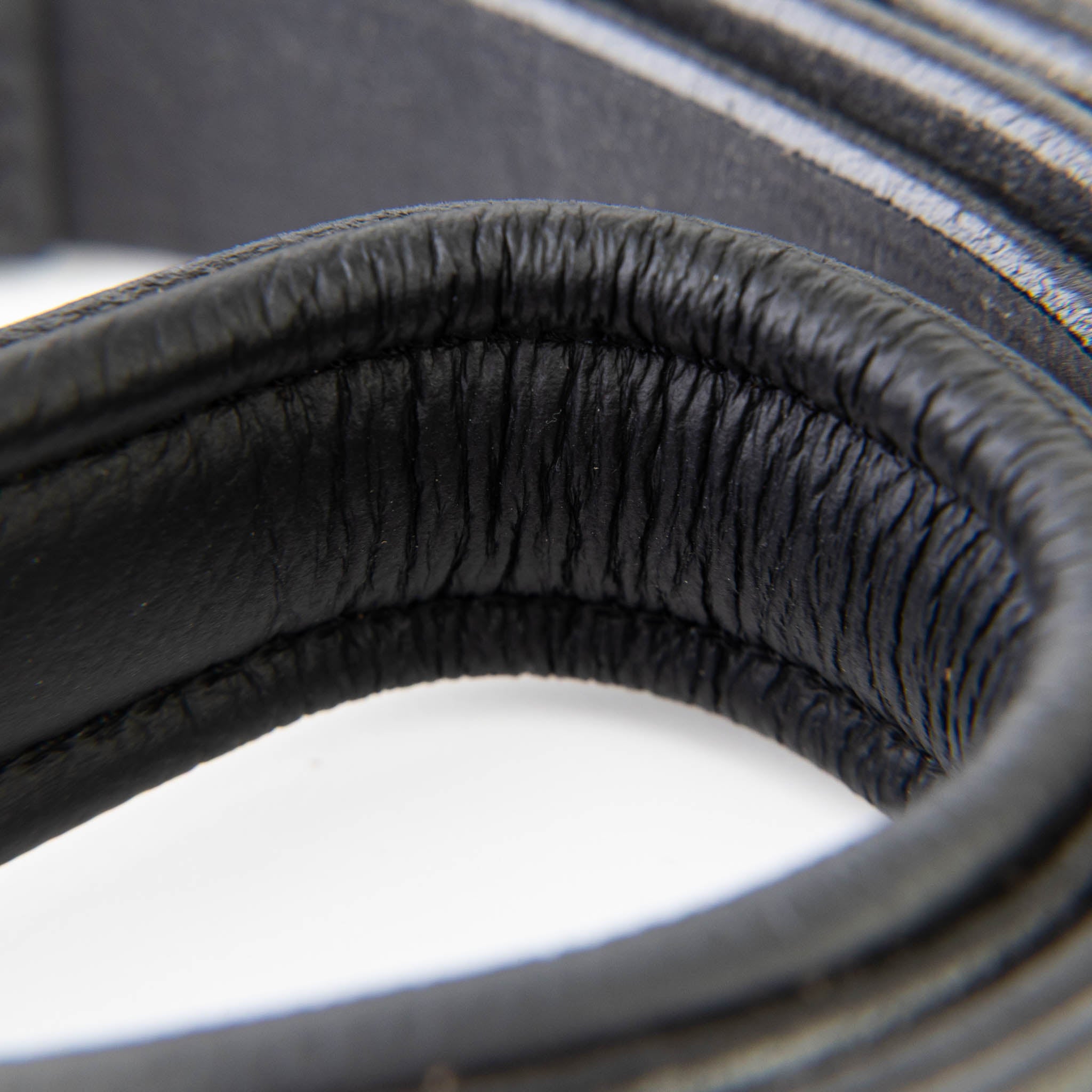 Close-up of a black earbud with a blurred background
