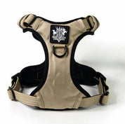 A tan and black Rogue Royalty dog harness with a black brand patch on the chest, displayed on a clean white background.