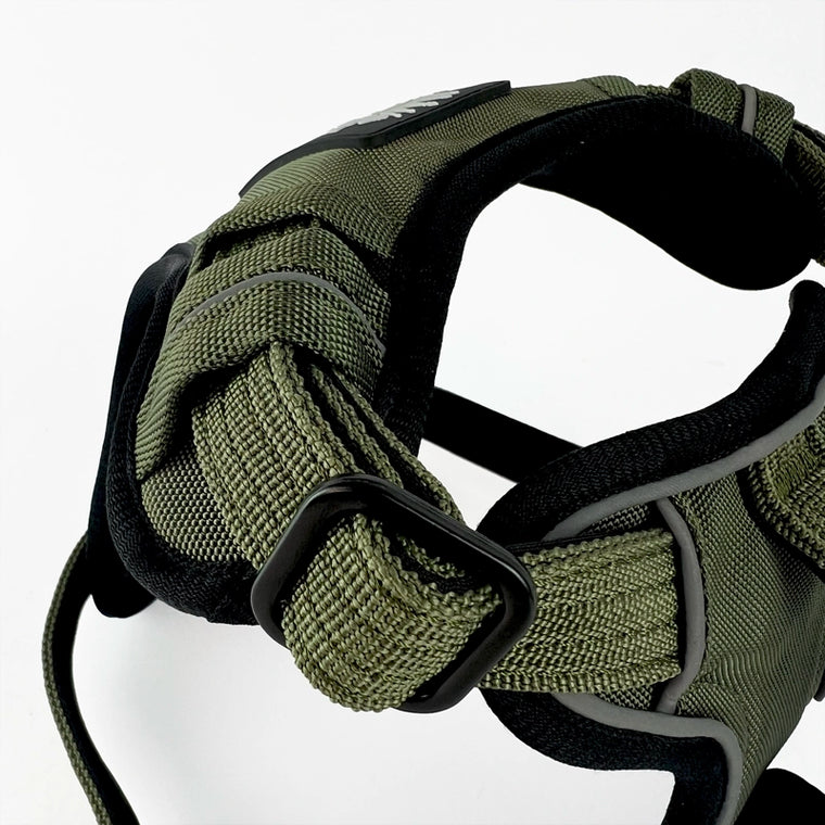Close-up of a Rogue Royalty support padded dog harness in olive green and black, showing the adjustable webbing, black plastic buckle, and padded interior straps against a white background.